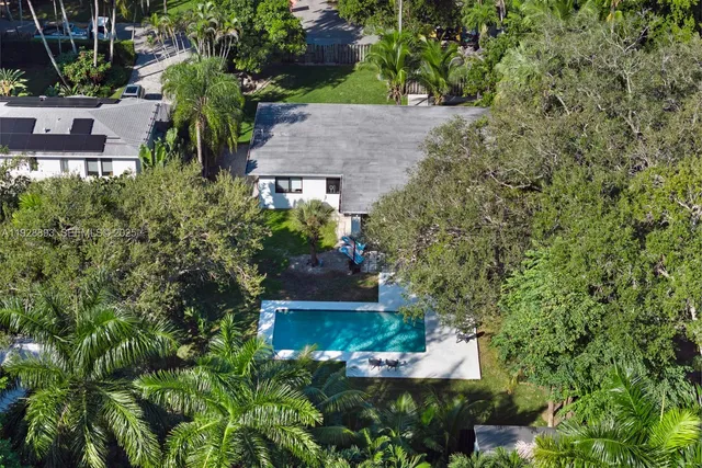 an aerial view of a house with a yard lake and outdoor seating