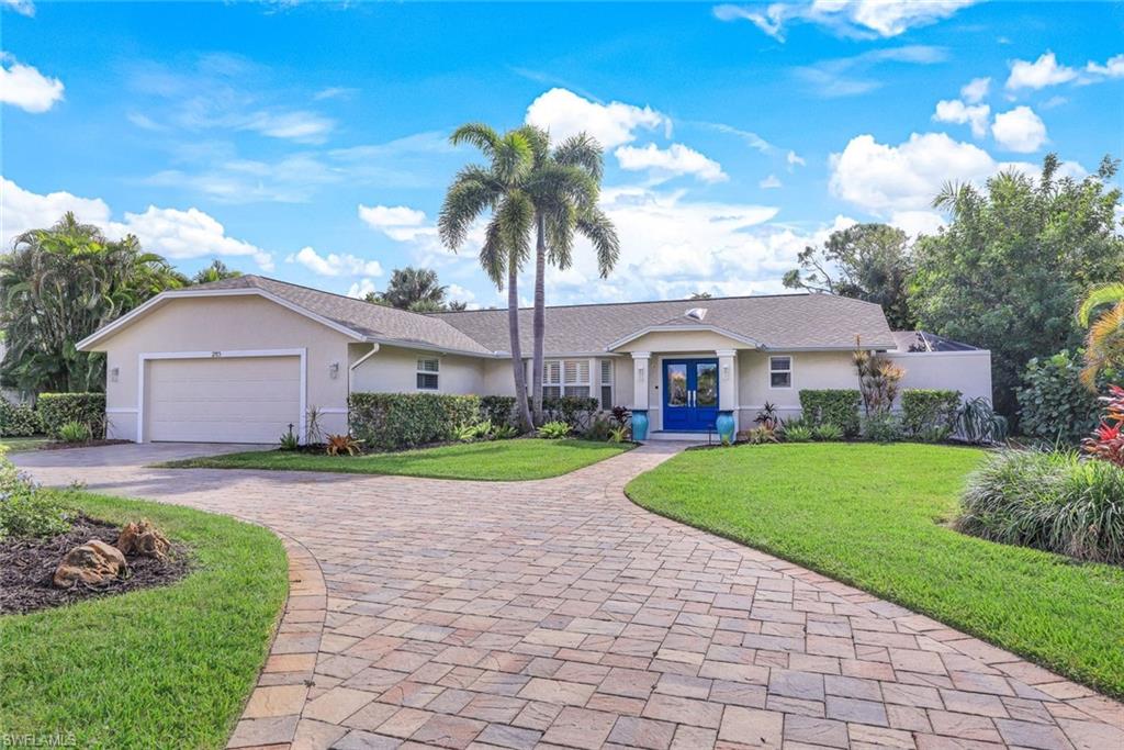 2113 Imperial Golf Course Boulevard Naples, FL 34110 - Photo 1 of 42 a front view of a house with a yard and garage