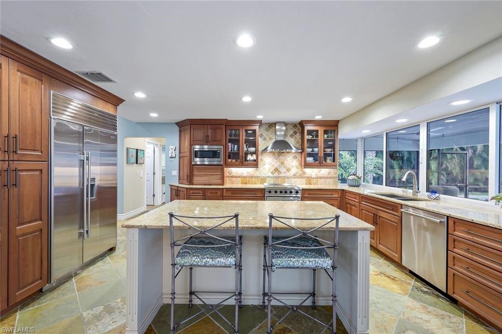 2113 Imperial Golf Course Boulevard Naples, FL 34110 - Photo 21 of 42 a large kitchen with a table and chairs
