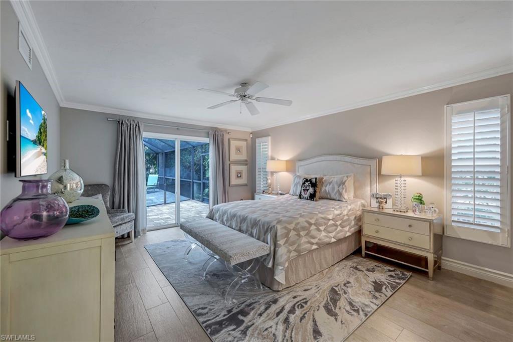 2113 Imperial Golf Course Boulevard Naples, FL 34110 - Photo 22 of 42 a bedroom with a bed and a chandelier