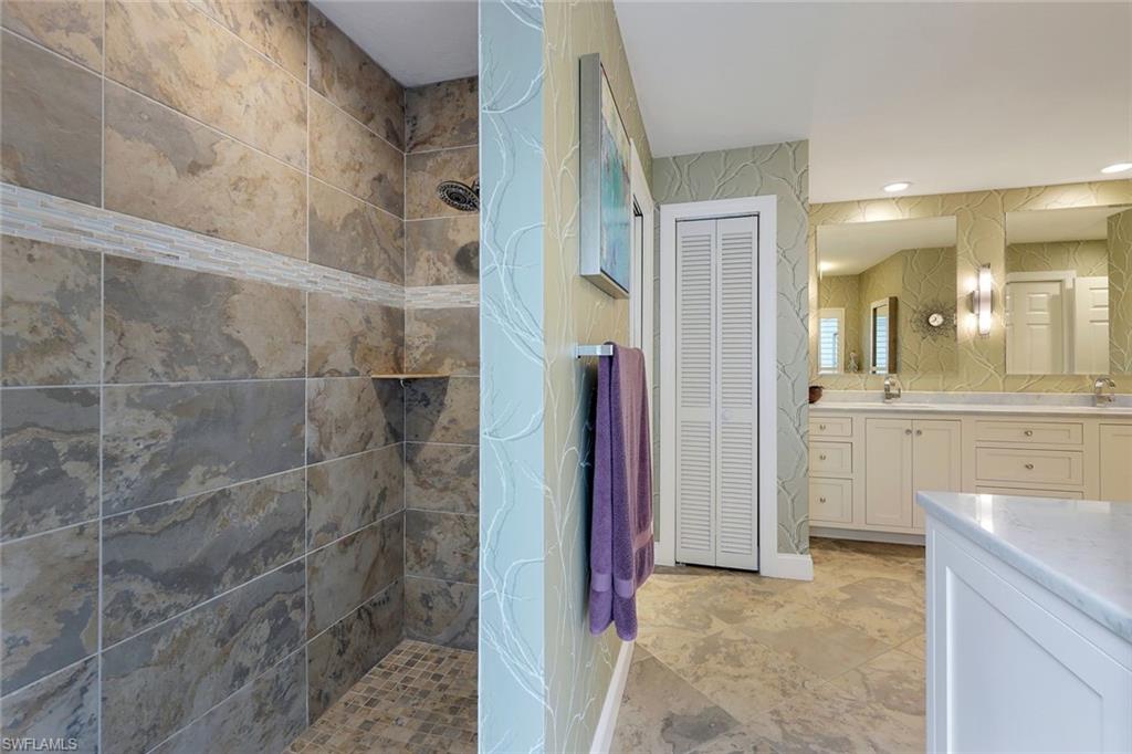 2113 Imperial Golf Course Boulevard Naples, FL 34110 - Photo 25 of 42 a bathroom with a sink and a mirror