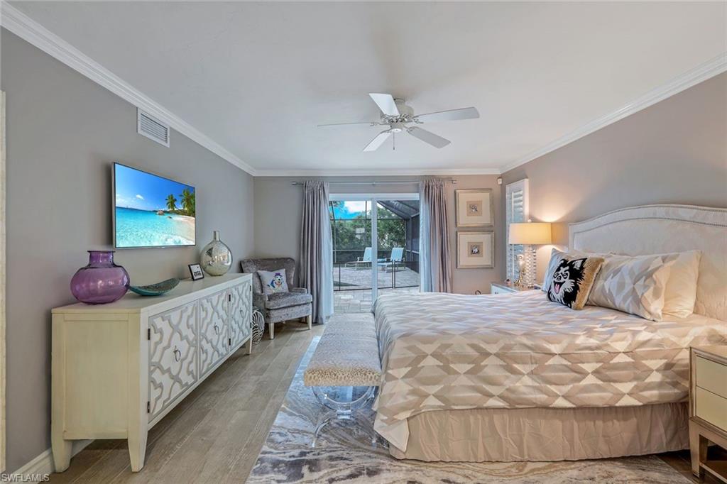 2113 Imperial Golf Course Boulevard Naples, FL 34110 - Photo 27 of 42 a bed room with a bed window and a chandelier