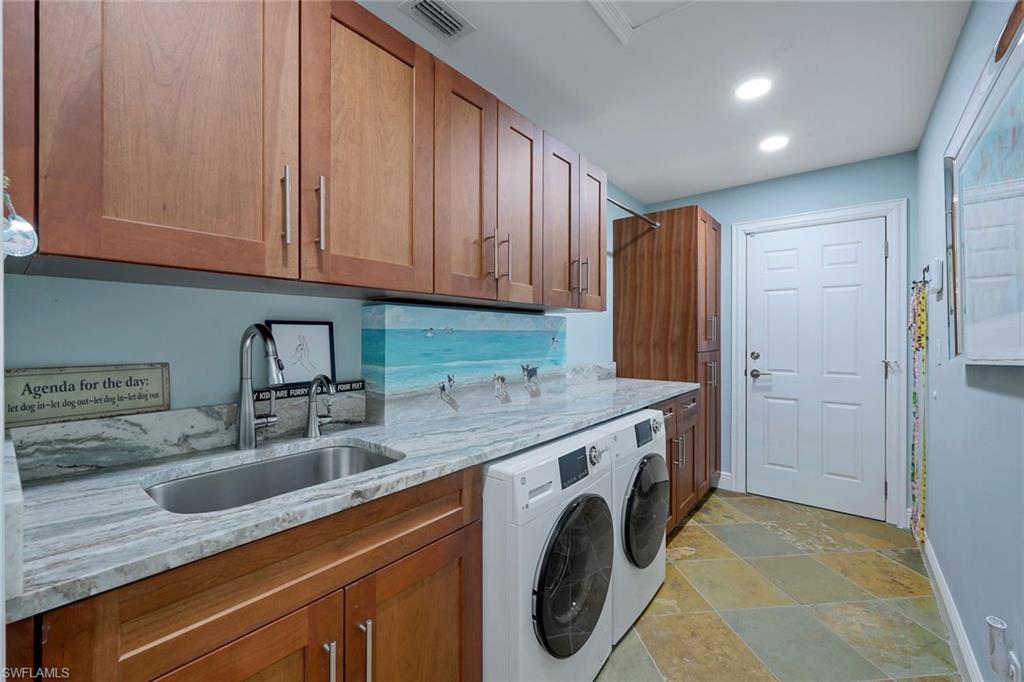 2113 Imperial Golf Course Boulevard Naples, FL 34110 - Photo 31 of 42 a utility room with stainless steel appliances granite countertop a sink and a washer dryer