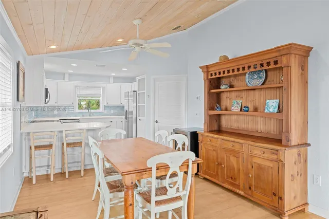 a dining area with stainless steel appliances kitchen island granite countertop a dining table and chairs