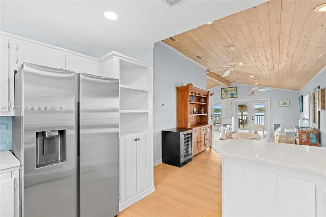 a kitchen with stainless steel appliances kitchen island granite countertop a refrigerator and a sink