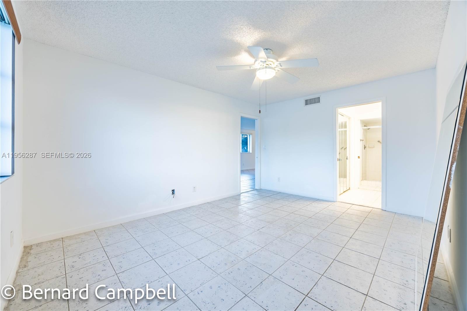 7264 South Devon Drive, Unit 112 Tamarac, FL 33321 - Photo 22 of 45 an empty room with white walls and chandelier fan