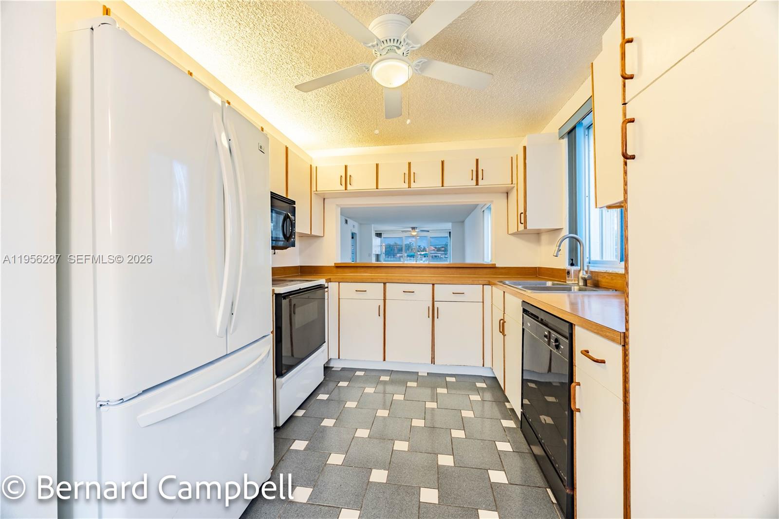 7264 South Devon Drive, Unit 112 Tamarac, FL 33321 - Photo 4 of 45 a kitchen with granite countertop a sink stove and refrigerator