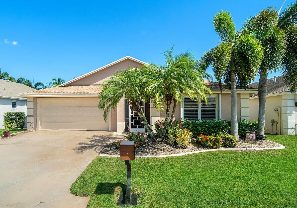 front view of house with a yard and potted plants