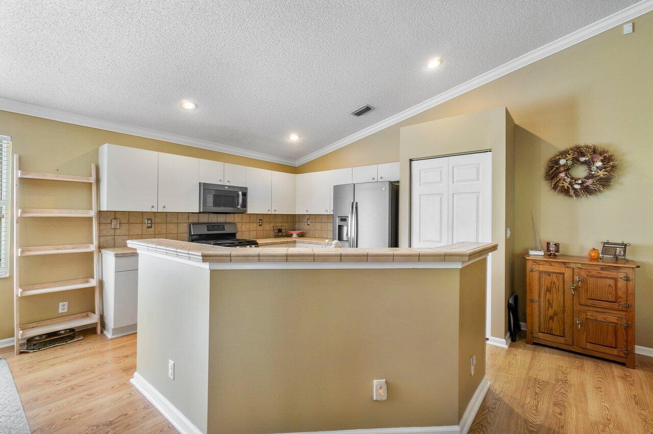 1410 Bethpage Way Greenacres, FL 33413 - Photo 9 of 29 a kitchen with stainless steel appliances a refrigerator and a stove top oven