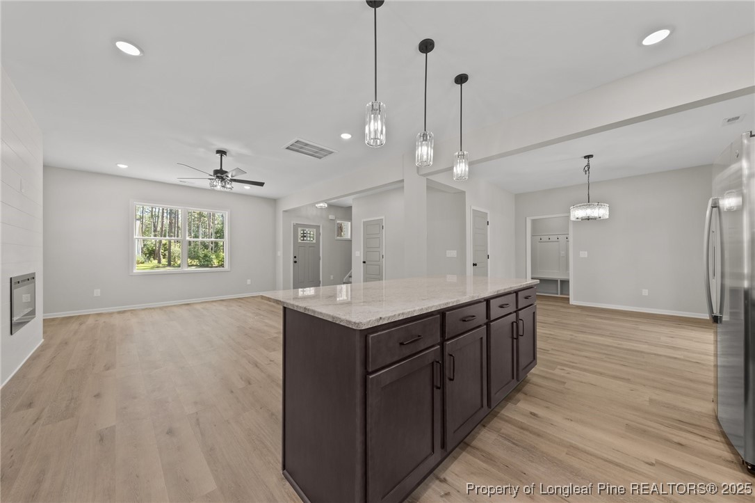 15980 Old Orchard Court Wagram, NC 28396 - Photo 13 of 33 a large kitchen with stainless steel appliances granite countertop a sink and a wooden floor