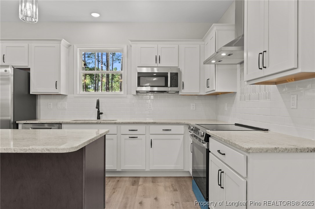 15980 Old Orchard Court Wagram, NC 28396 - Photo 18 of 33 a kitchen with stainless steel appliances granite countertop a sink stove and microwave