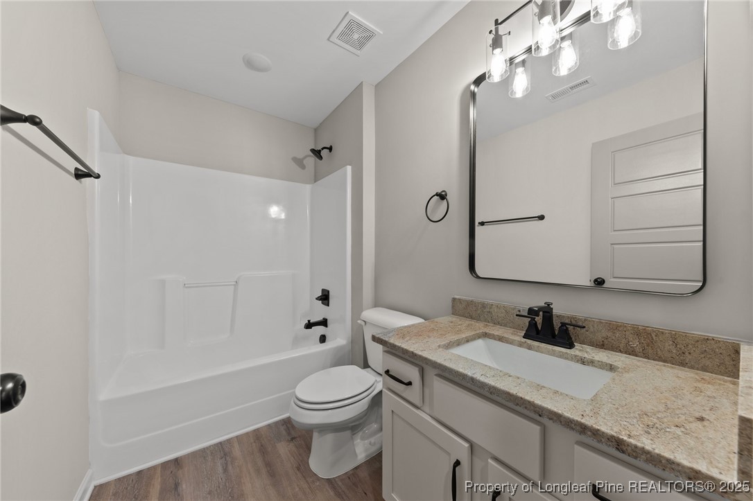 15980 Old Orchard Court Wagram, NC 28396 - Photo 30 of 33 a bathroom with a granite countertop sink a toilet and bathtub