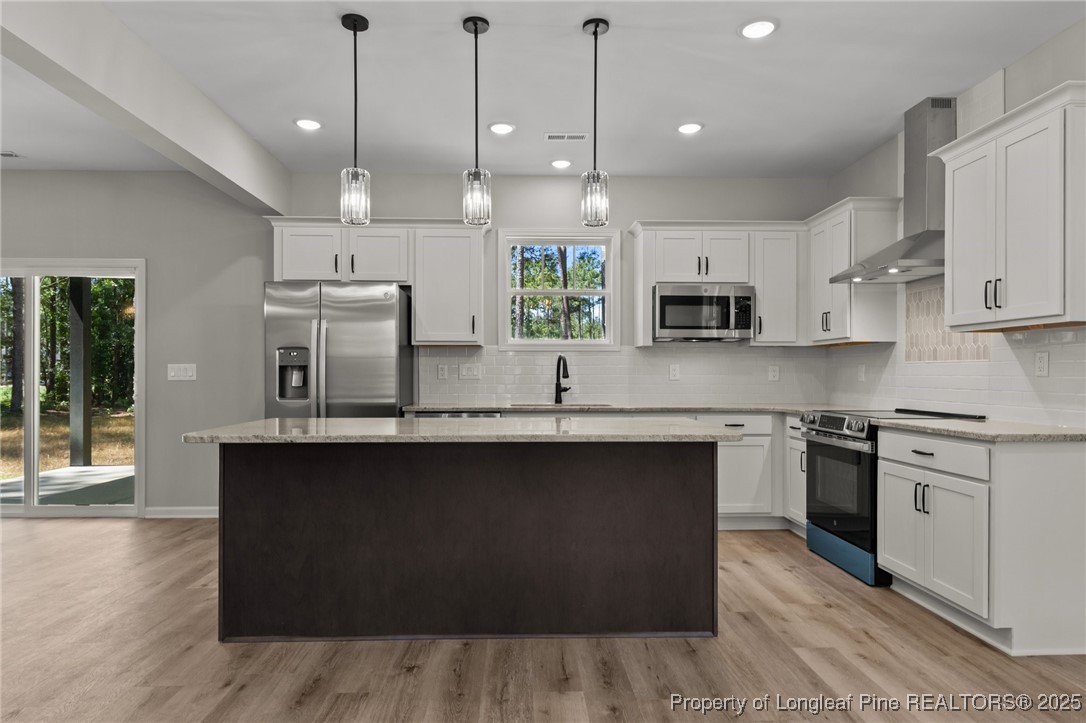15980 Old Orchard Court Wagram, NC 28396 - Photo 9 of 33 a kitchen with stainless steel appliances granite countertop a sink a stove and a wooden floor