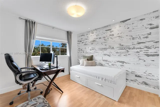 a bedroom with a bed and large windows