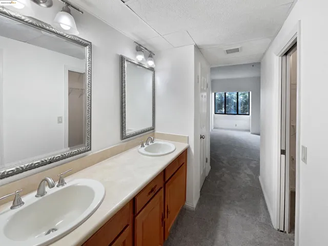 a spacious bathroom with a double vanity sink and mirror