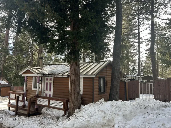 a front view of a house with a yard covered in snow