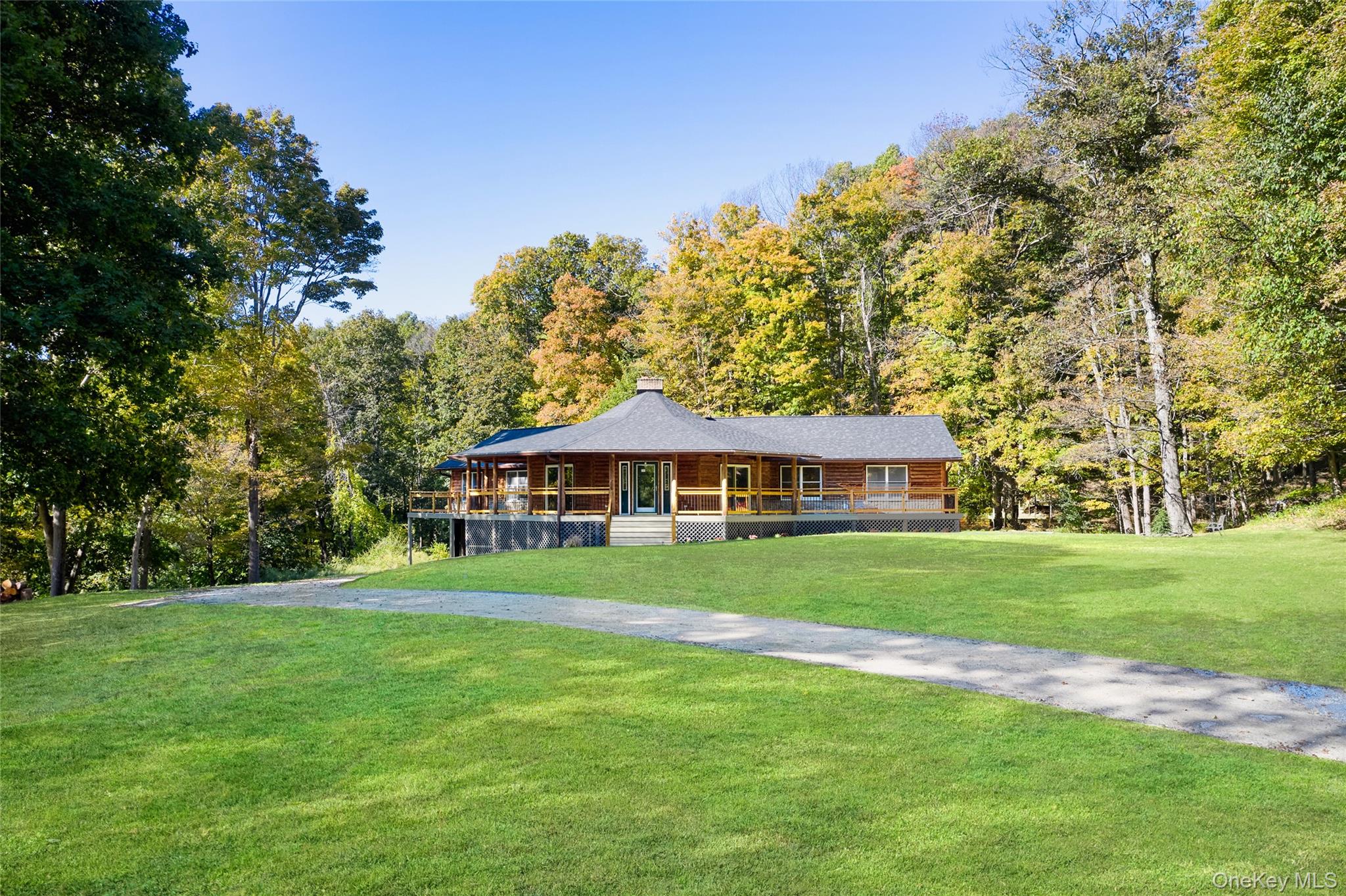568 Oak Summit Road Millbrook, NY 12545 - Photo 1 of 50 View of front facade featuring a porch, a front yard, a chimney, and a wooded view