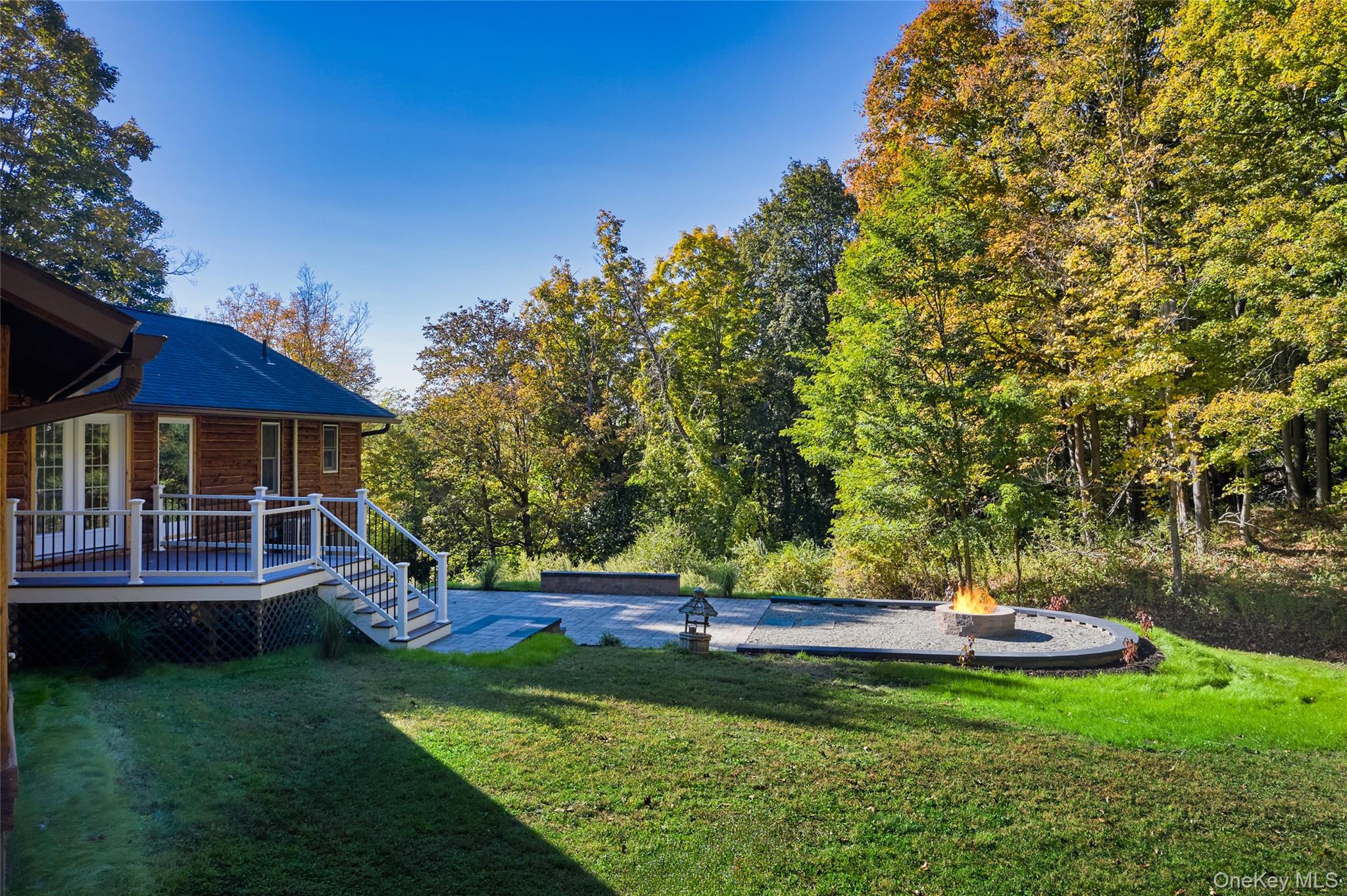 568 Oak Summit Road Millbrook, NY 12545 - Photo 40 of 50 View of grassy yard featuring an outdoor fire pit, a patio area, and a deck