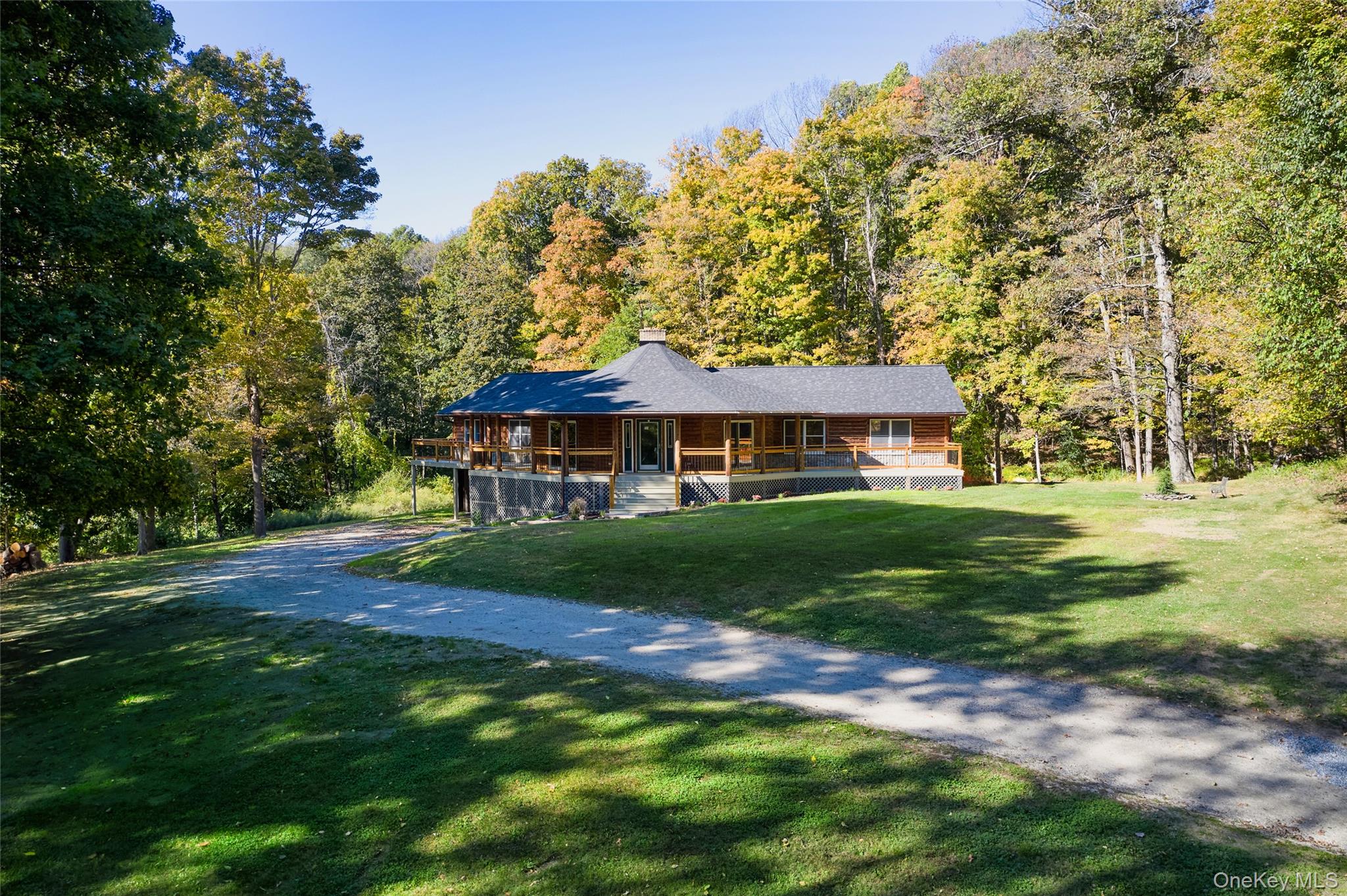 568 Oak Summit Road Millbrook, NY 12545 - Photo 4 of 50 View of front of home with covered porch, a front lawn, a wooded view, a chimney, and driveway