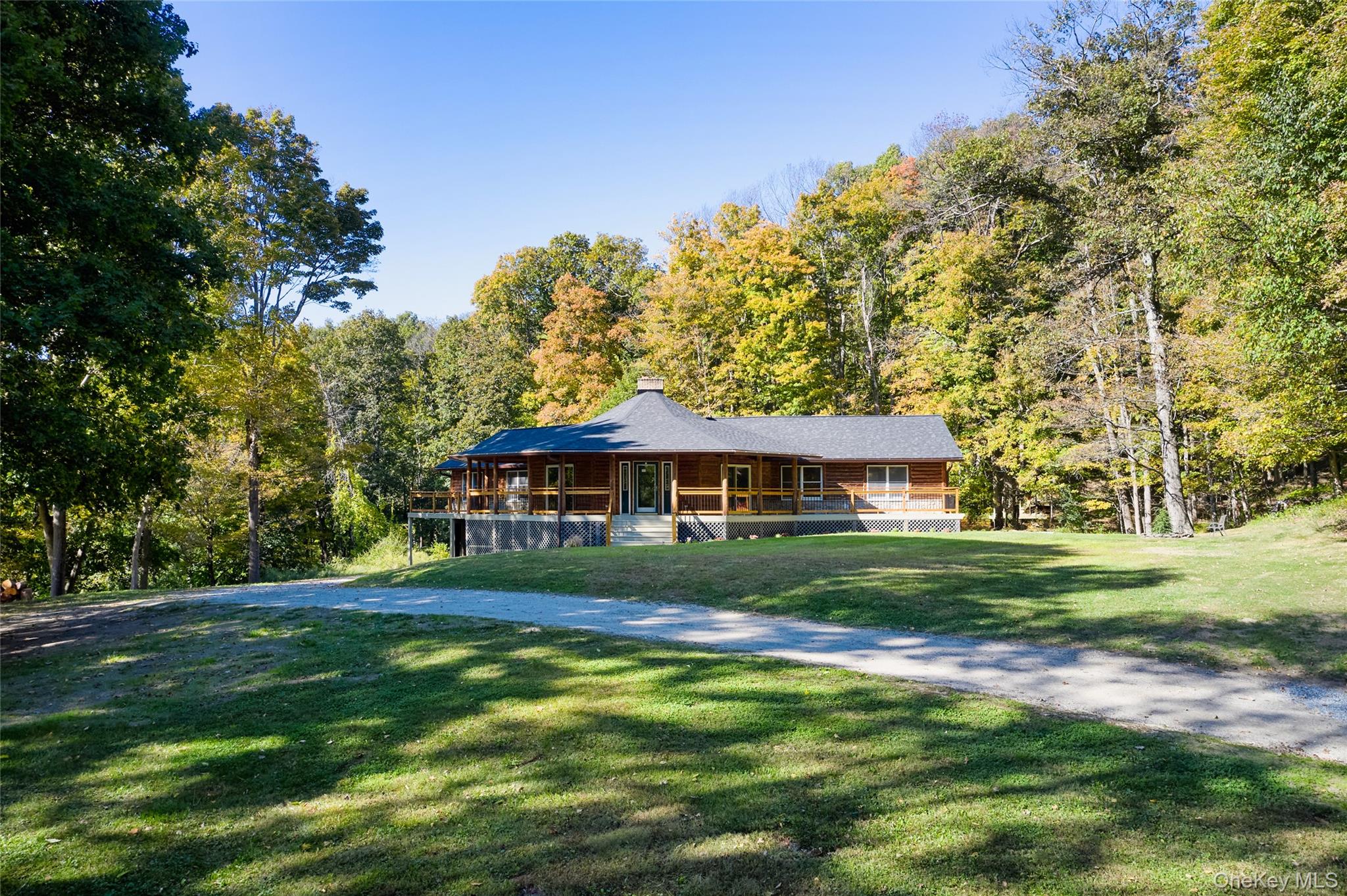568 Oak Summit Road Millbrook, NY 12545 - Photo 43 of 50 View of front of house with a large porch, a front yard, a chimney, and a wooded view