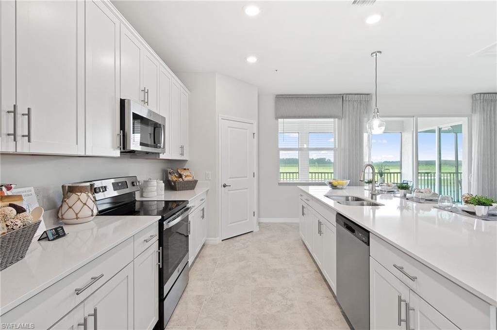 6008 Ellerston Way Avenue, Unit 1021 Immokalee, FL 34142 - Photo 15 of 50 Kitchen with appliances with stainless steel finishes, white cabinetry, hanging light fixtures, recessed lighting, and light stone counters