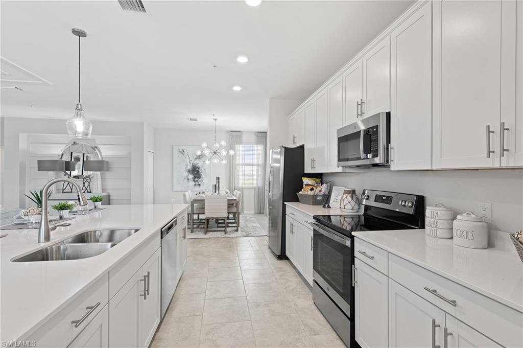 6008 Ellerston Way Avenue, Unit 1021 Immokalee, FL 34142 - Photo 16 of 50 Kitchen with stainless steel appliances, white cabinetry, hanging light fixtures, light tile patterned flooring, and recessed lighting
