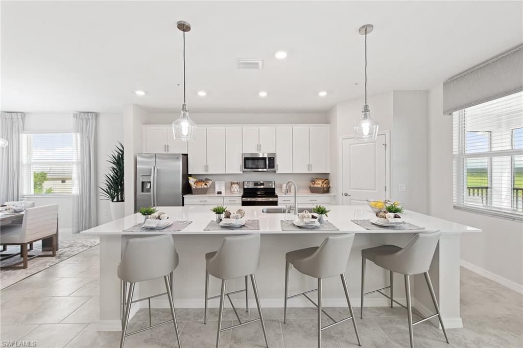6008 Ellerston Way Avenue, Unit 1021 Immokalee, FL 34142 - Photo 21 of 50 Kitchen with healthy amount of natural light, white cabinetry, a breakfast bar area, pendant lighting, and recessed lighting