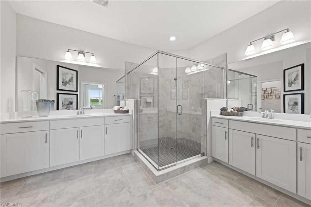 6008 Ellerston Way Avenue, Unit 1021 Immokalee, FL 34142 - Photo 34 of 50 Bathroom featuring two vanities, a shower stall, and light tile patterned floors