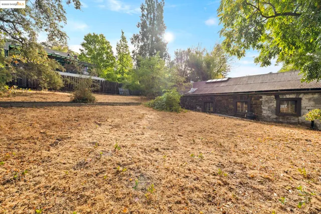a view of a yard with wooden fence