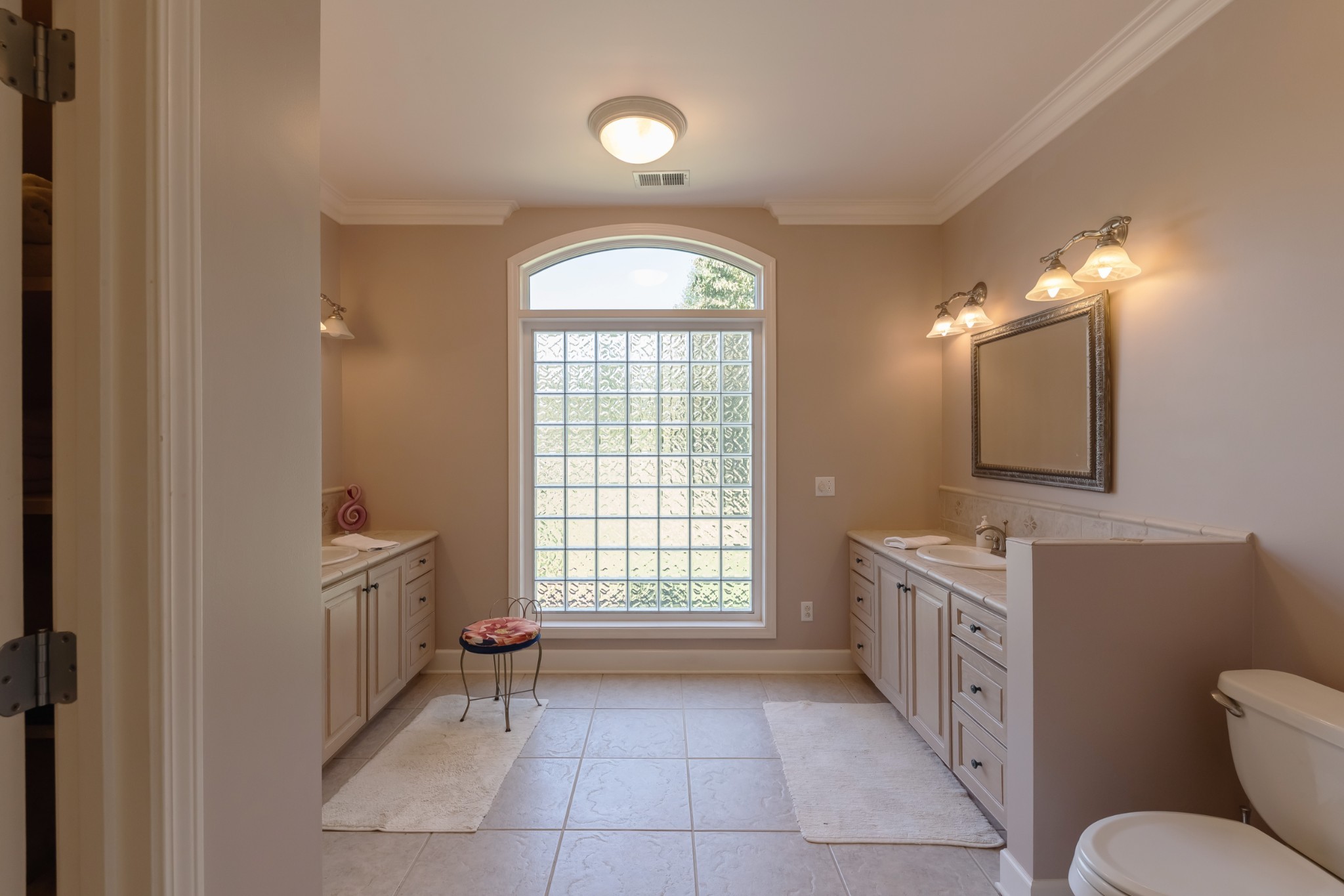 7650 Sleepy Summit Road Fairview, TN 37062 - Photo 15 of 30 a spacious bathroom with a toilet a sink a mirror a window and vanity