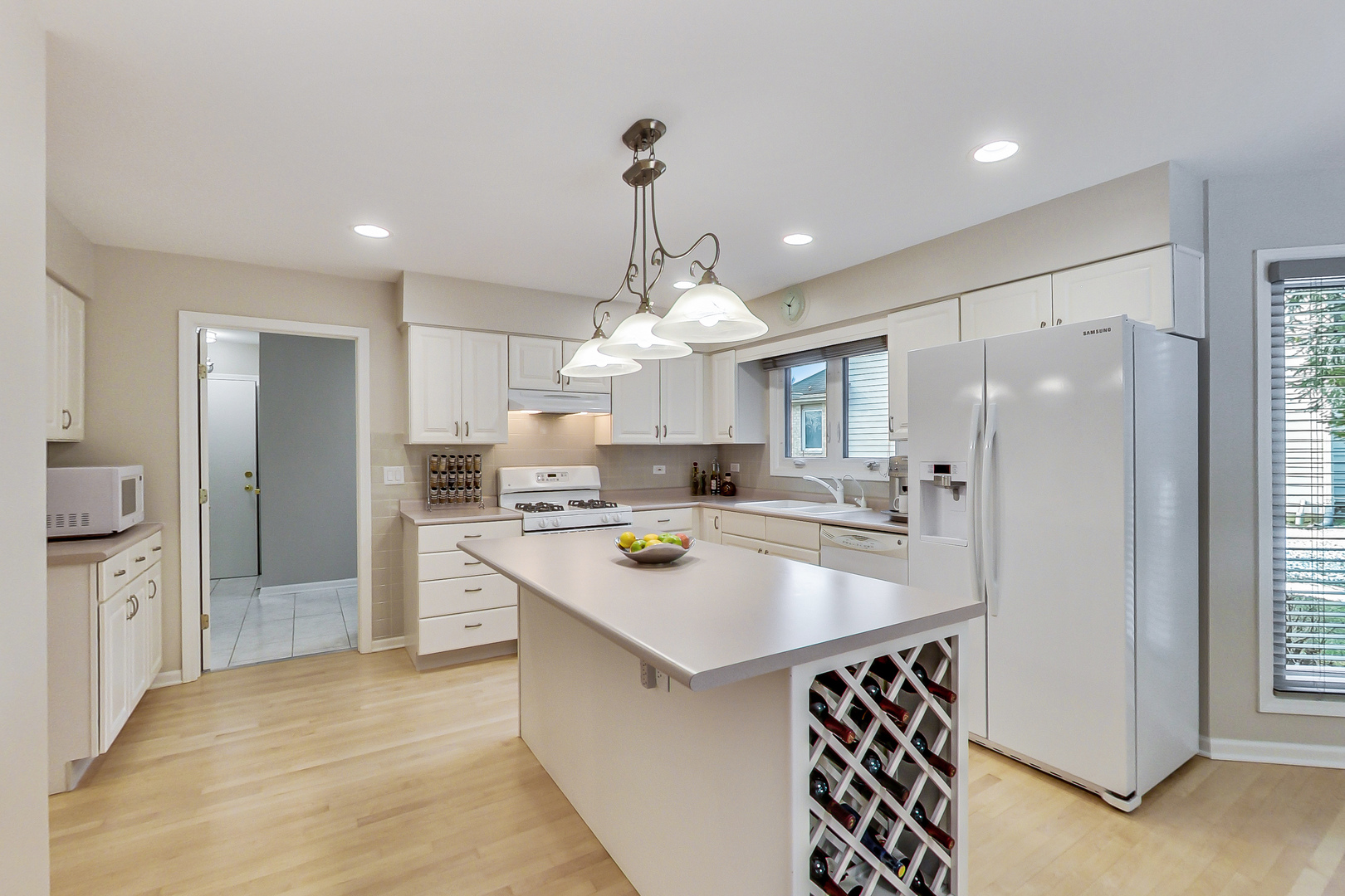790 Edgemere Road Buffalo Grove, IL 60089 - Photo 12 of 42 a kitchen with stainless steel appliances granite countertop a refrigerator a sink dishwasher a stove and white cabinets with wooden floor