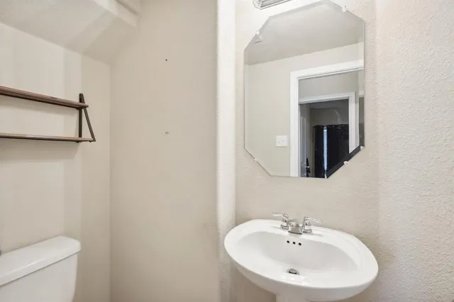 a bathroom with a sink a toilet and mirror