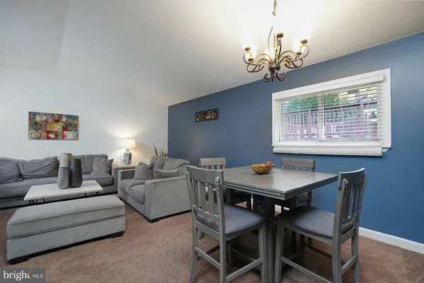 a living room with furniture a chandelier and a window