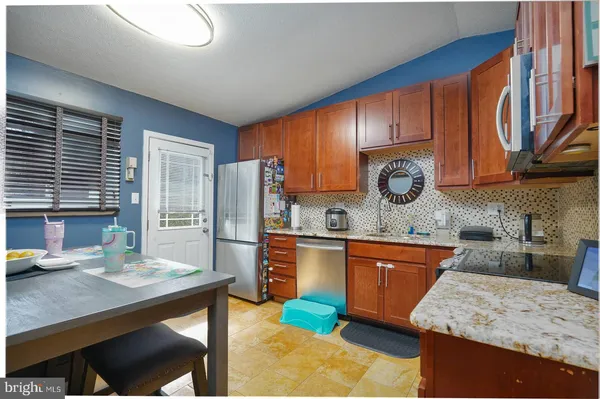 a kitchen with stainless steel appliances granite countertop wooden cabinets a sink stove and granite counter top