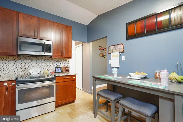 a kitchen with stainless steel appliances a stove microwave and refrigerator