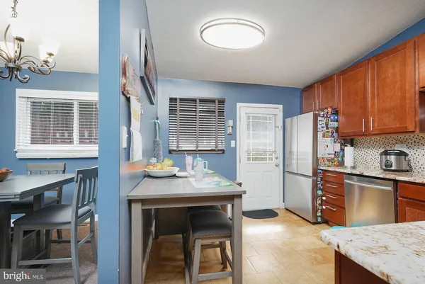 a kitchen with stainless steel appliances granite countertop a stove top oven a refrigerator a sink and dishwasher
