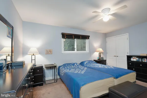 a bedroom with a bed a table with chair and window