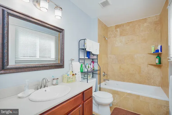 a bathroom with a sink vanity mirror and toilet