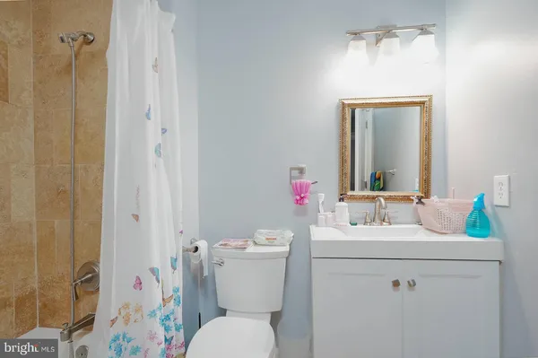 a bathroom with a sink toilet vanity and shower