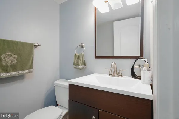 a bathroom with a sink mirror vanity and toilet