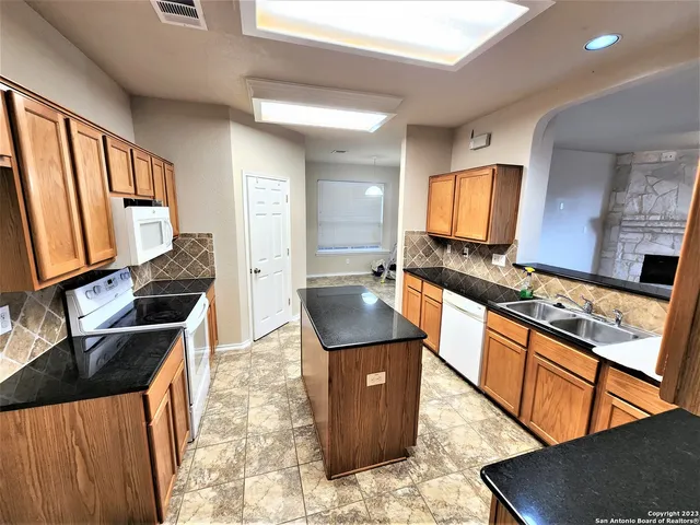 a kitchen with stainless steel appliances granite countertop a stove a sink and a microwave