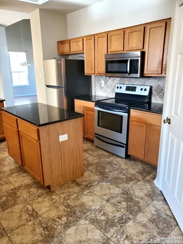 a kitchen with stainless steel appliances a stove a microwave and a refrigerator