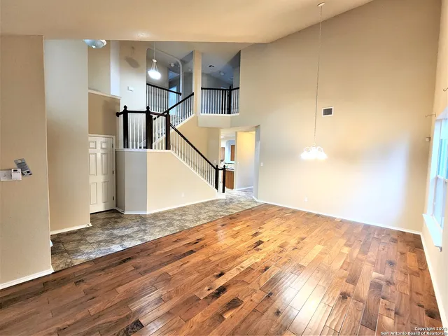 a view of a big room with wooden floor and stairs
