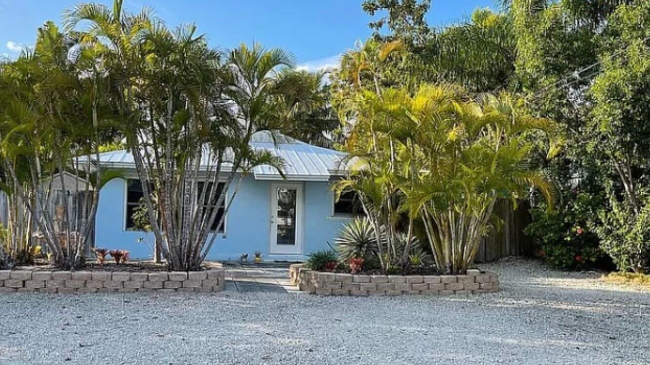 a front view of a house with a tree