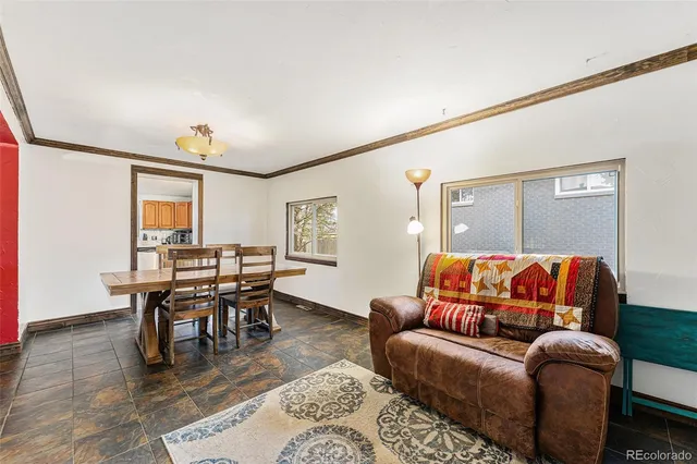 a living room with furniture a dining table and a bookshelf with wooden floor