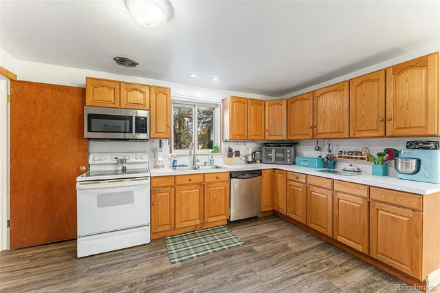 a kitchen with stainless steel appliances granite countertop a stove a sink dishwasher and a refrigerator