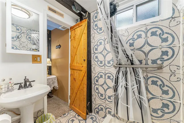 a bathroom with a sink and mirror with shower