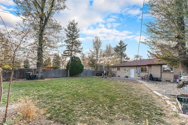 a view of a house with a yard and trees