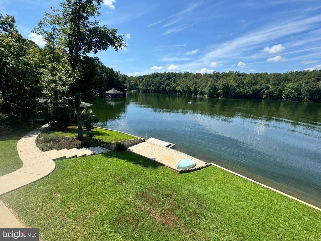 8 Elnor Road Bumpass, VA 23024 - Photo 12 of 13 Serene lakeside retreat with lush greenery.