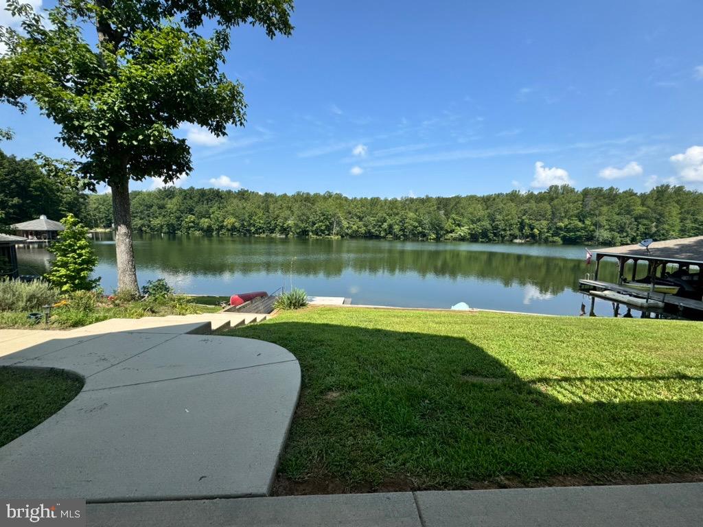 8 Elnor Road Bumpass, VA 23024 - Photo 2 of 13 Serene lakeside retreat with lush greenery.